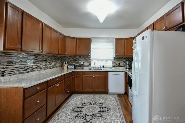 719 N Keowee St, Dayton, OH 45404 - kitchen featuring white appliances, dark wood-style floors, decorative backsplash, and brown cabinetry