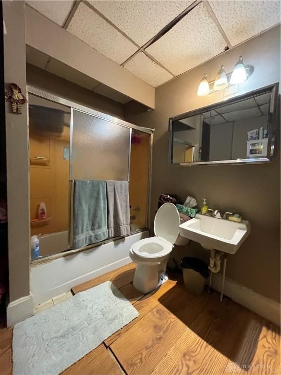 419 Baltimore St, Middletown, OH 45044 - bathroom with a drop ceiling, bath / shower combo with glass door, and wood finished floors