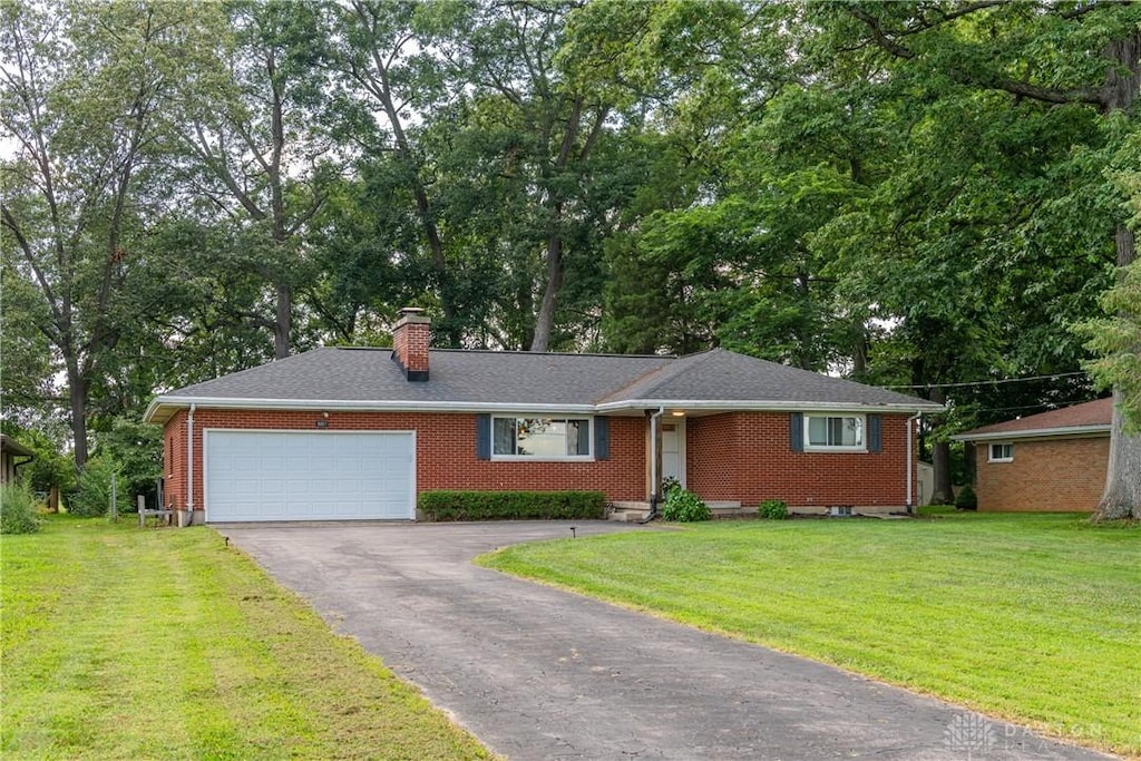 5057 W Enon Rd, Fairborn, OH 45324 - ranch-style home featuring a garage, driveway, a chimney, and a front lawn