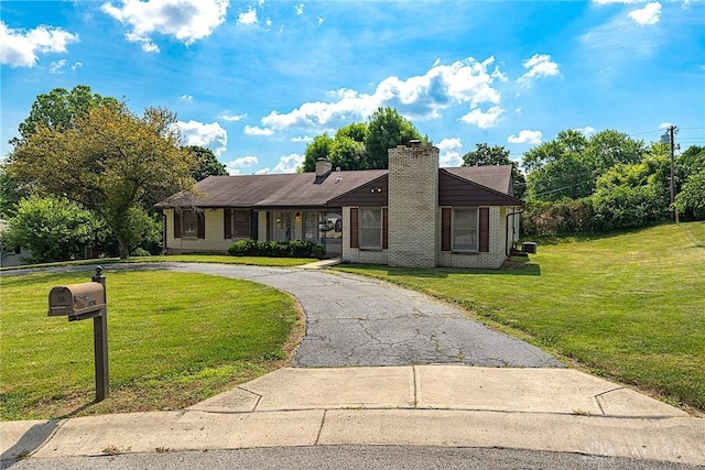 5282 Rahway Ct, Clayton, OH 45415 - view of front of property with a front yard, a chimney, curved driveway, and brick siding