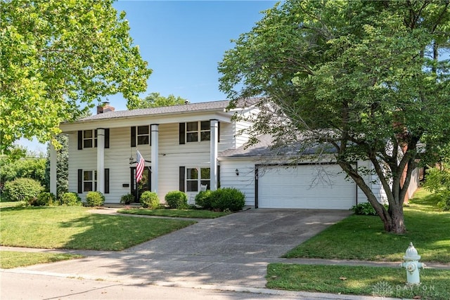 1269 Redbud Dr, Fairborn, OH 45324 - greek revival inspired property featuring concrete driveway, a chimney, a front lawn, and an attached garage