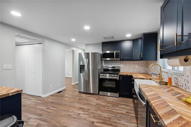 5433 Pentland Cir, Huber Heights, OH 45424 - kitchen with wood counters, stainless steel appliances, wood finished floors, backsplash, and recessed lighting