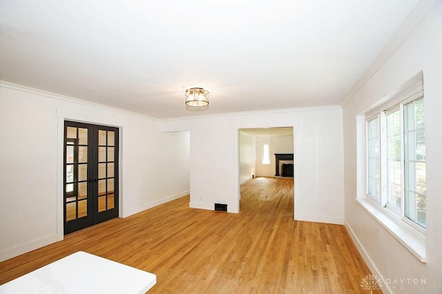 1151 Brookview Ave, Dayton, OH 45409 - empty room with light wood-style floors, crown molding, a fireplace, and french doors