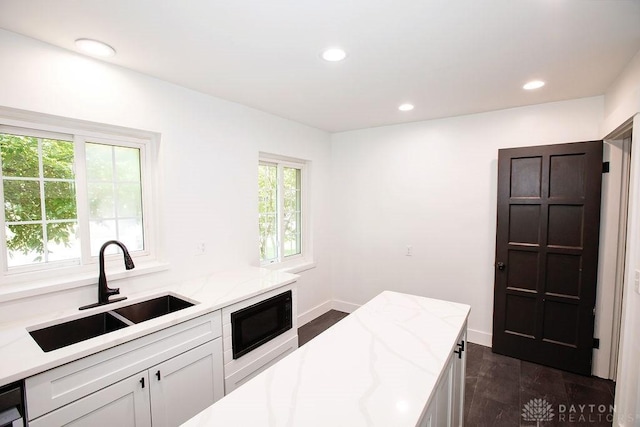 1151 Brookview Ave, Dayton, OH 45409 - kitchen with black microwave, light stone countertops, dark wood-style floors, white cabinets, and recessed lighting