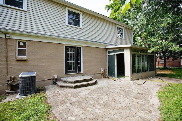 1151 Brookview Ave, Dayton, OH 45409 - rear view of house featuring a sunroom, a patio area, and brick siding