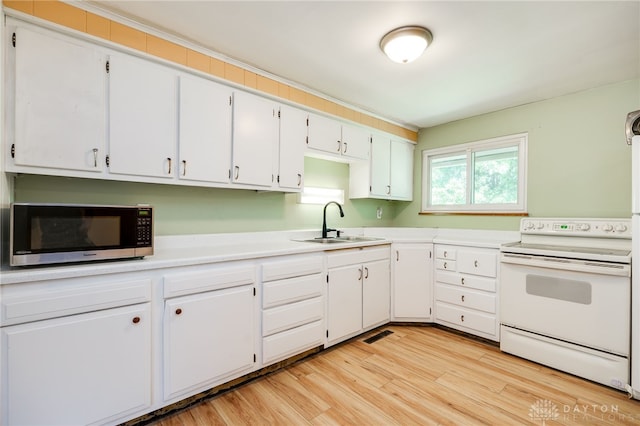 57 Pollyanna Ave, Germantown, OH 45327 - kitchen featuring electric range, stainless steel microwave, light countertops, light wood-style flooring, and white cabinetry