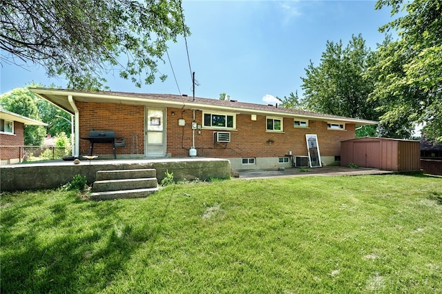 57 Pollyanna Ave, Germantown, OH 45327 - back of property featuring a lawn, brick siding, a storage unit, and a patio area