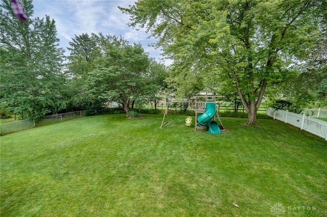 338 Chatham Dr, Fairborn, OH 45324 - fenced backyard with a playground and view of scattered trees