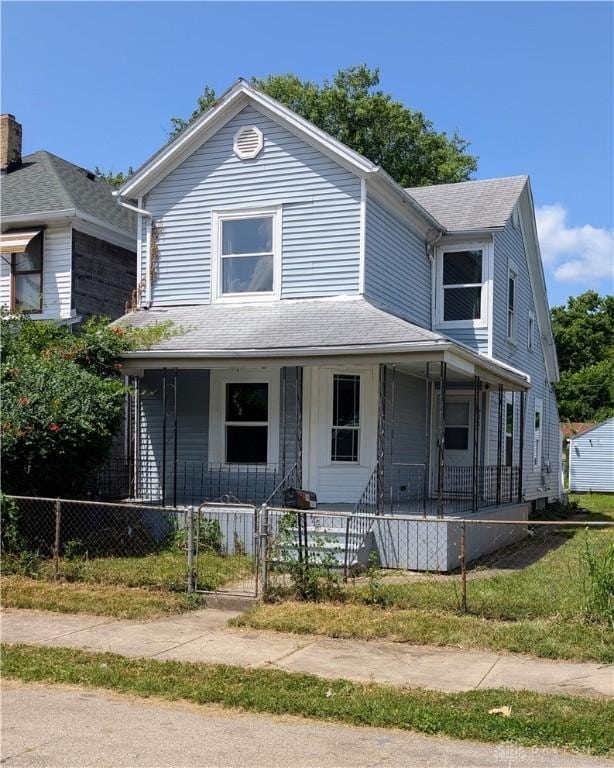 633 Taylor St, Dayton, OH 45404 - view of front of home with a porch, a fenced front yard, and a shingled roof