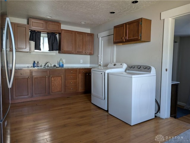 633 Taylor St, Dayton, OH 45404 - laundry room featuring washing machine and dryer, wood finished floors, a textured ceiling, cabinet space, and recessed lighting