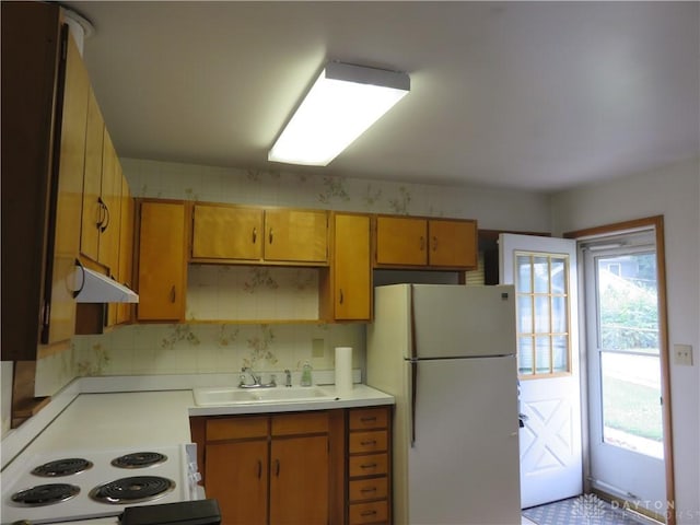 2830 Kennedy Ave, Dayton, OH 45420 - kitchen with white appliances, light countertops, under cabinet range hood, decorative backsplash, and brown cabinetry