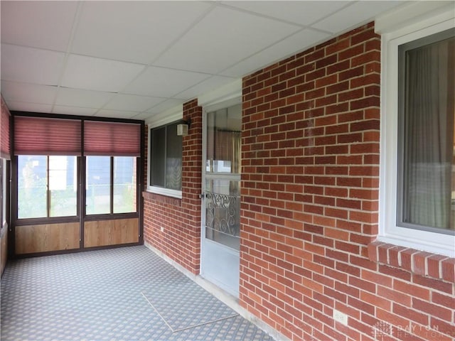 2830 Kennedy Ave, Dayton, OH 45420 - unfurnished sunroom featuring brick wall, a drop ceiling, and carpet flooring
