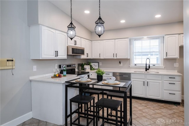 130 Mound St, Dayton, OH 45402 - kitchen featuring appliances with stainless steel finishes, white cabinets, hanging light fixtures, light countertops, and recessed lighting