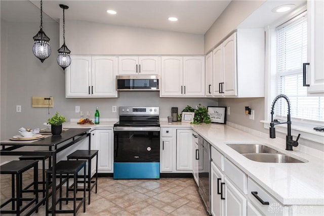 130 Mound St, Dayton, OH 45402 - kitchen featuring appliances with stainless steel finishes, hanging light fixtures, white cabinetry, stone finish floors, and recessed lighting