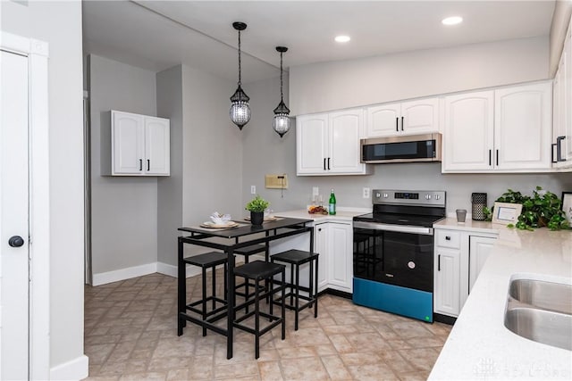 130 Mound St, Dayton, OH 45402 - kitchen with stainless steel appliances, light countertops, pendant lighting, white cabinetry, and recessed lighting