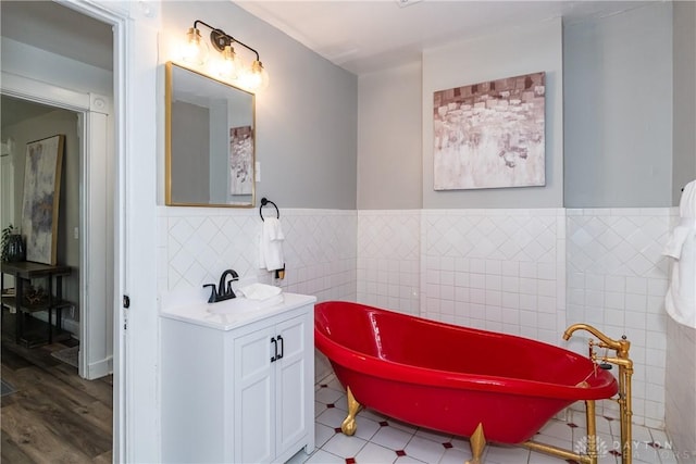 130 Mound St, Dayton, OH 45402 - full bathroom with tile walls, vanity, a freestanding tub, and a wainscoted wall