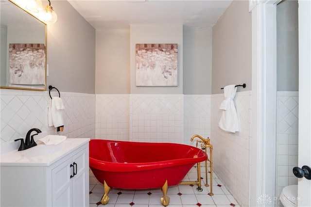 130 Mound St, Dayton, OH 45402 - full bath featuring a freestanding bath, wainscoting, tile walls, vanity, and tile patterned flooring