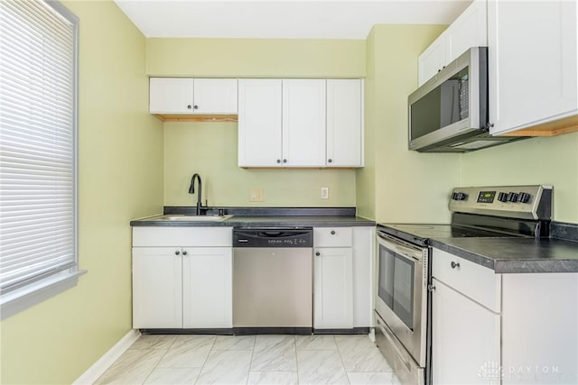 349 E Xenia Dr, Fairborn, OH 45324 - kitchen featuring stainless steel appliances, dark countertops, light marble finish flooring, and white cabinetry