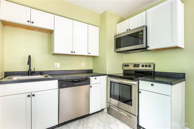 349 E Xenia Dr, Fairborn, OH 45324 - kitchen with stainless steel appliances, dark countertops, light marble finish floors, and white cabinetry