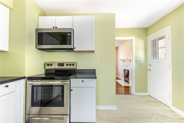 349 E Xenia Dr, Fairborn, OH 45324 - kitchen with appliances with stainless steel finishes, dark countertops, white cabinetry, and light marble finish floors