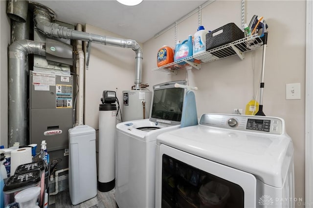 670 Saxony Dr, Xenia, OH 45385 - washroom featuring washing machine and clothes dryer, gas water heater, and wood finished floors