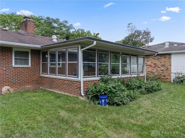 670 Saxony Dr, Xenia, OH 45385 - view of side of property with brick siding, a lawn, a chimney, and a sunroom