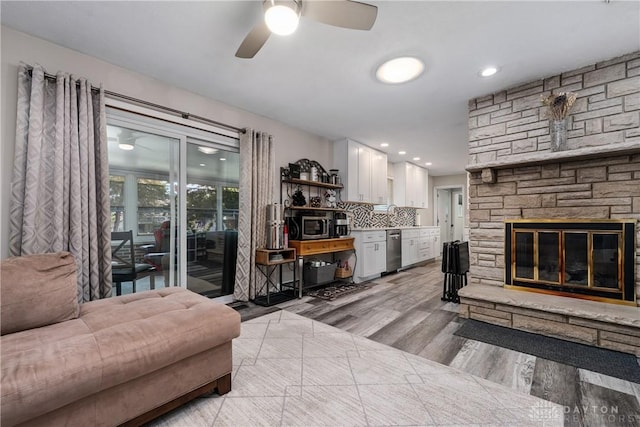 670 Saxony Dr, Xenia, OH 45385 - living area with a stone fireplace, light wood-type flooring, and ceiling fan