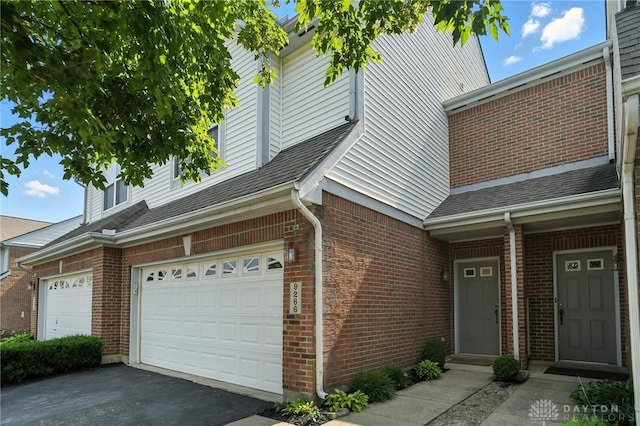 9266 Great Lakes Cir, Washington Twp, OH 45458 - view of side of home with brick siding, driveway, a shingled roof, and an attached garage