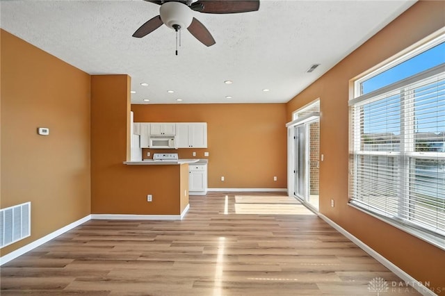 9266 Great Lakes Cir, Washington Twp, OH 45458 - unfurnished living room with light wood-type flooring, ceiling fan, recessed lighting, and a textured ceiling
