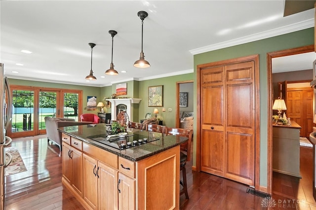 95 Sycamore Creek Dr, Springboro, OH 45066 - kitchen with black electric cooktop, dark wood-style flooring, dark stone counters, a kitchen bar, and a kitchen island