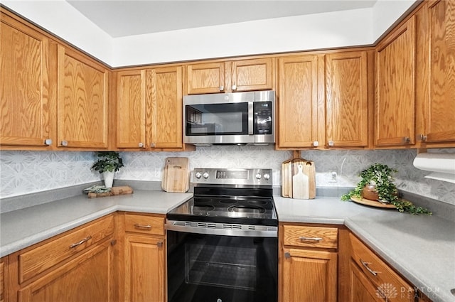 3755 Everett Dr, Loveland, OH 45140 - kitchen with stainless steel appliances, light countertops, backsplash, and brown cabinets
