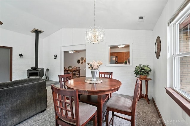 3755 Everett Dr, Loveland, OH 45140 - dining room with carpet floors, lofted ceiling, a wood stove, and a chandelier