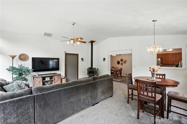 3755 Everett Dr, Loveland, OH 45140 - living area with a wood stove, vaulted ceiling, ceiling fan, a chandelier, and light colored carpet