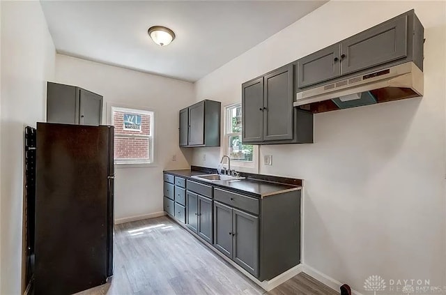 233 Alton Ave, Dayton, OH 45404 - kitchen with freestanding refrigerator, under cabinet range hood, light wood-type flooring, and dark countertops