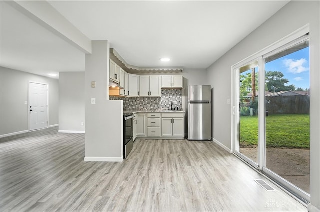 1393 Seminole Dr, Xenia, OH 45385 - kitchen featuring freestanding refrigerator, stove, light wood-style flooring, light countertops, and backsplash