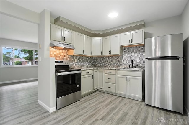 1393 Seminole Dr, Xenia, OH 45385 - kitchen featuring stainless steel appliances, under cabinet range hood, light wood finished floors, and decorative backsplash