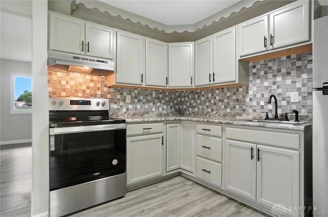 1393 Seminole Dr, Xenia, OH 45385 - kitchen with stainless steel electric stove, under cabinet range hood, light wood-style floors, and tasteful backsplash