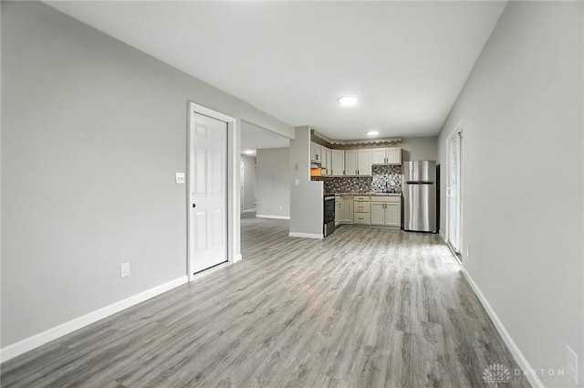 1393 Seminole Dr, Xenia, OH 45385 - unfurnished living room with baseboards and light wood-style flooring