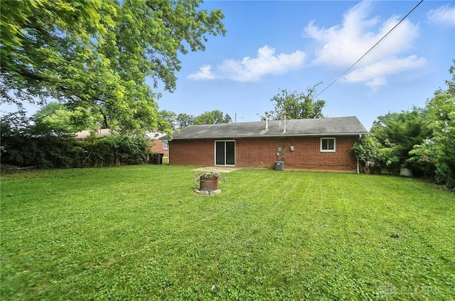 1393 Seminole Dr, Xenia, OH 45385 - back of property featuring a yard, brick siding, and a fire pit