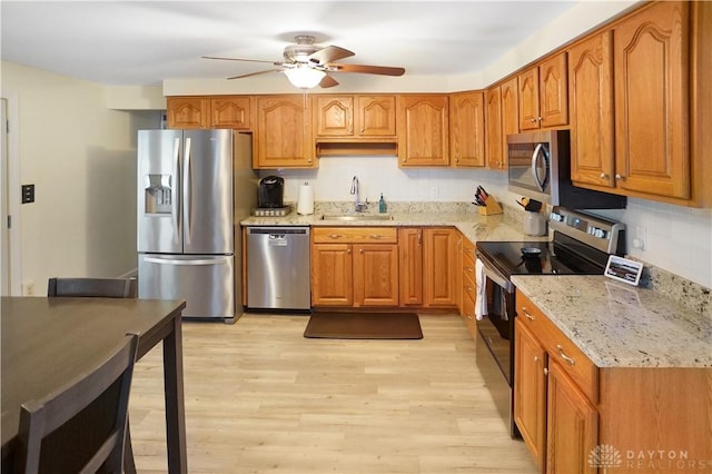 1464 New Way Dr, Beavercreek, OH 45434 - kitchen featuring stainless steel appliances, ceiling fan, light stone countertops, and brown cabinets