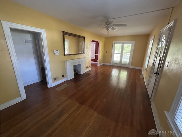 725 Sunnyview Ave, Dayton, OH 45406 - unfurnished living room with ceiling fan, dark wood-style floors, a fireplace, and arched walkways