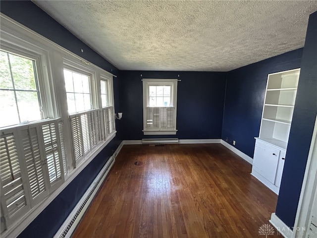 725 Sunnyview Ave, Dayton, OH 45406 - empty room with a textured ceiling, wood finished floors, and a baseboard heating unit