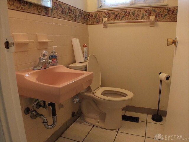 5582 Camerford Dr, Dayton, OH 45424 - bathroom featuring tile patterned flooring, healthy amount of natural light, wainscoting, and tile walls