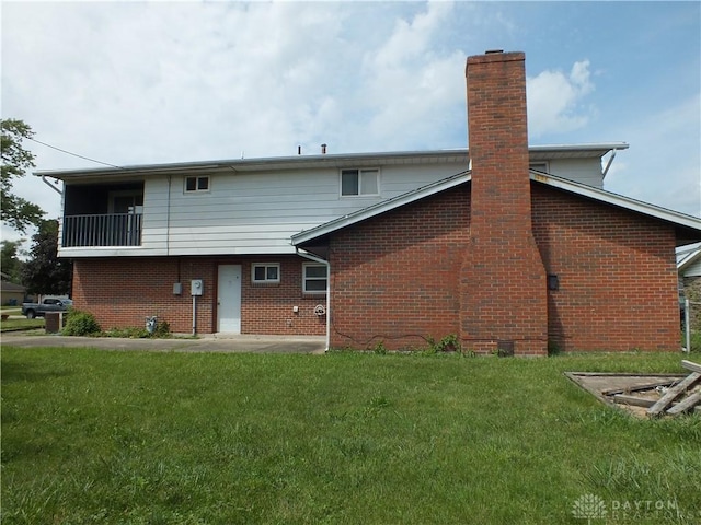 5582 Camerford Dr, Dayton, OH 45424 - rear view of house featuring a chimney, brick siding, and a yard