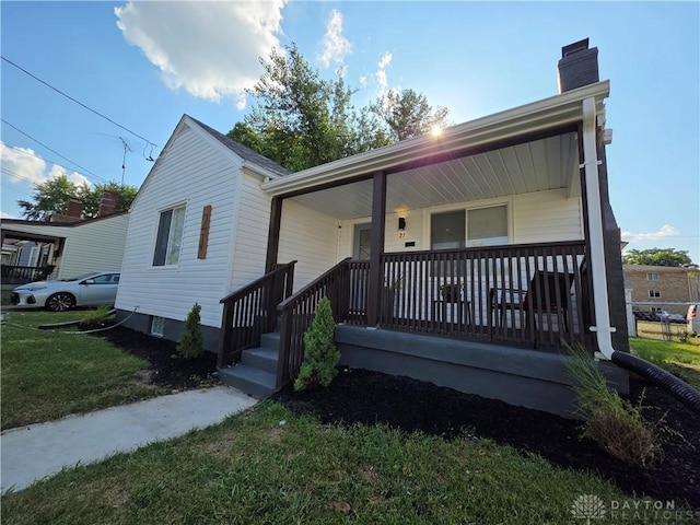 21 Anderson St, Dayton, OH 45410 - bungalow-style home featuring a porch, a chimney, and a front lawn