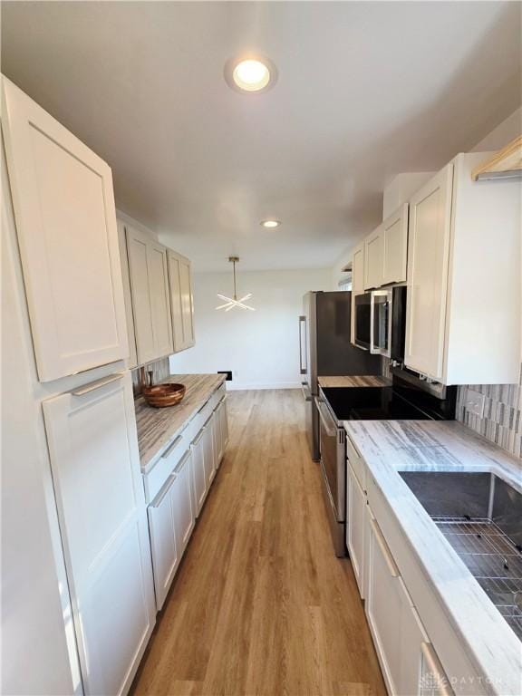 21 Anderson St, Dayton, OH 45410 - kitchen featuring electric stove, stainless steel microwave, white cabinetry, light wood finished floors, and recessed lighting