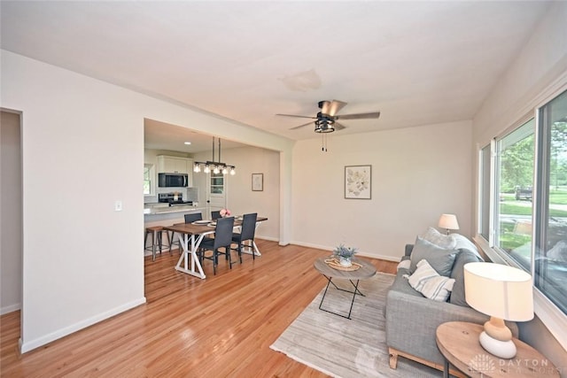 6383 Todhunter Rd, Middletown, OH 45044 - living room with light wood finished floors, a ceiling fan, and a chandelier