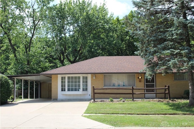 4912 Powell Rd, Huber Heights, OH 45424 - ranch-style home featuring brick siding, an attached carport, driveway, a front yard, and a shingled roof
