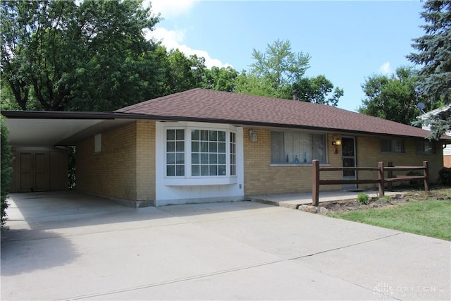 4912 Powell Rd, Huber Heights, OH 45424 - single story home with brick siding, concrete driveway, a carport, and roof with shingles
