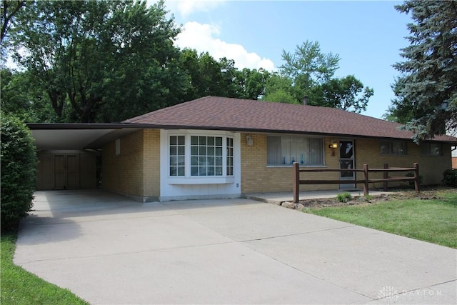 4912 Powell Rd, Huber Heights, OH 45424 - ranch-style house featuring driveway, brick siding, a carport, and covered porch